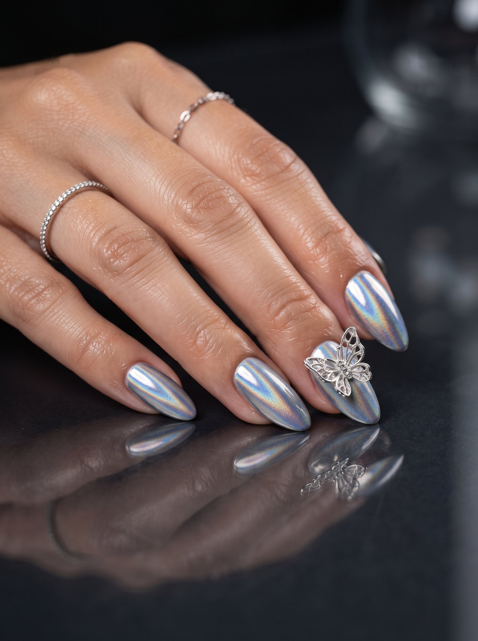Close-up of sleek almond-shaped nails featuring a highly reflective silver chrome finish.