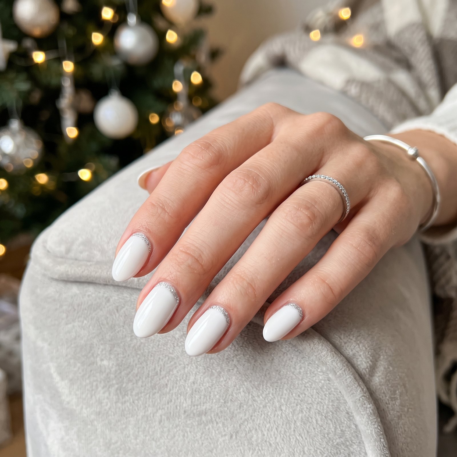Crisp white nails featuring fine gold glitter cuff accents along the cuticle line